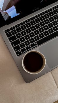 A top view of a coffee cup on a laptop keyboard, creating a cozy and productive atmosphere.