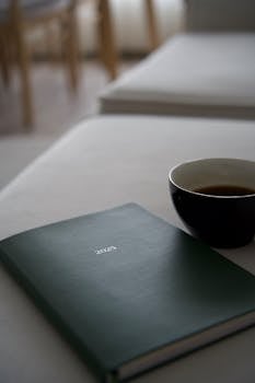 Elegant 2023 planner with a coffee cup on a table, perfect for planning and relaxation.
