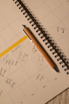 Wooden ballpoint pen resting on an open notebook, capturing planning and organization spirit.